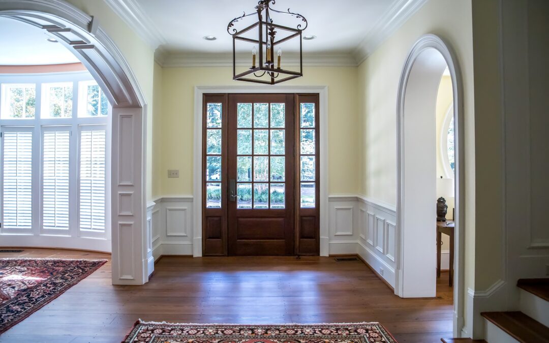 front entrance foyer hallway of a large home house with yellow walls and a wood door with windows and a custom wood mouldings